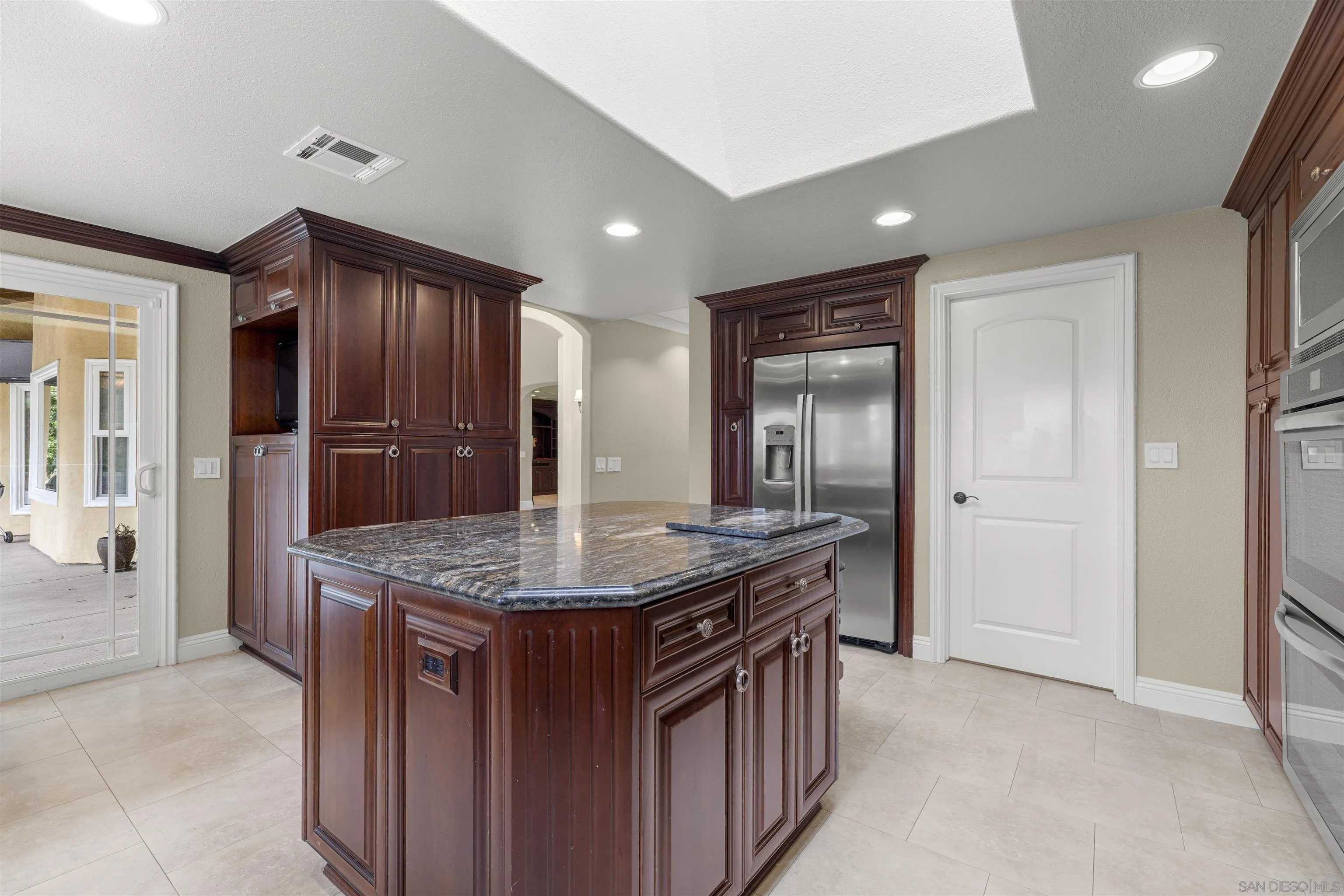 1315 Macadamia Drive Fallbrook, CA 92028 - Photo 14 of 59 a kitchen with stainless steel appliances granite countertop a sink and a refrigerator