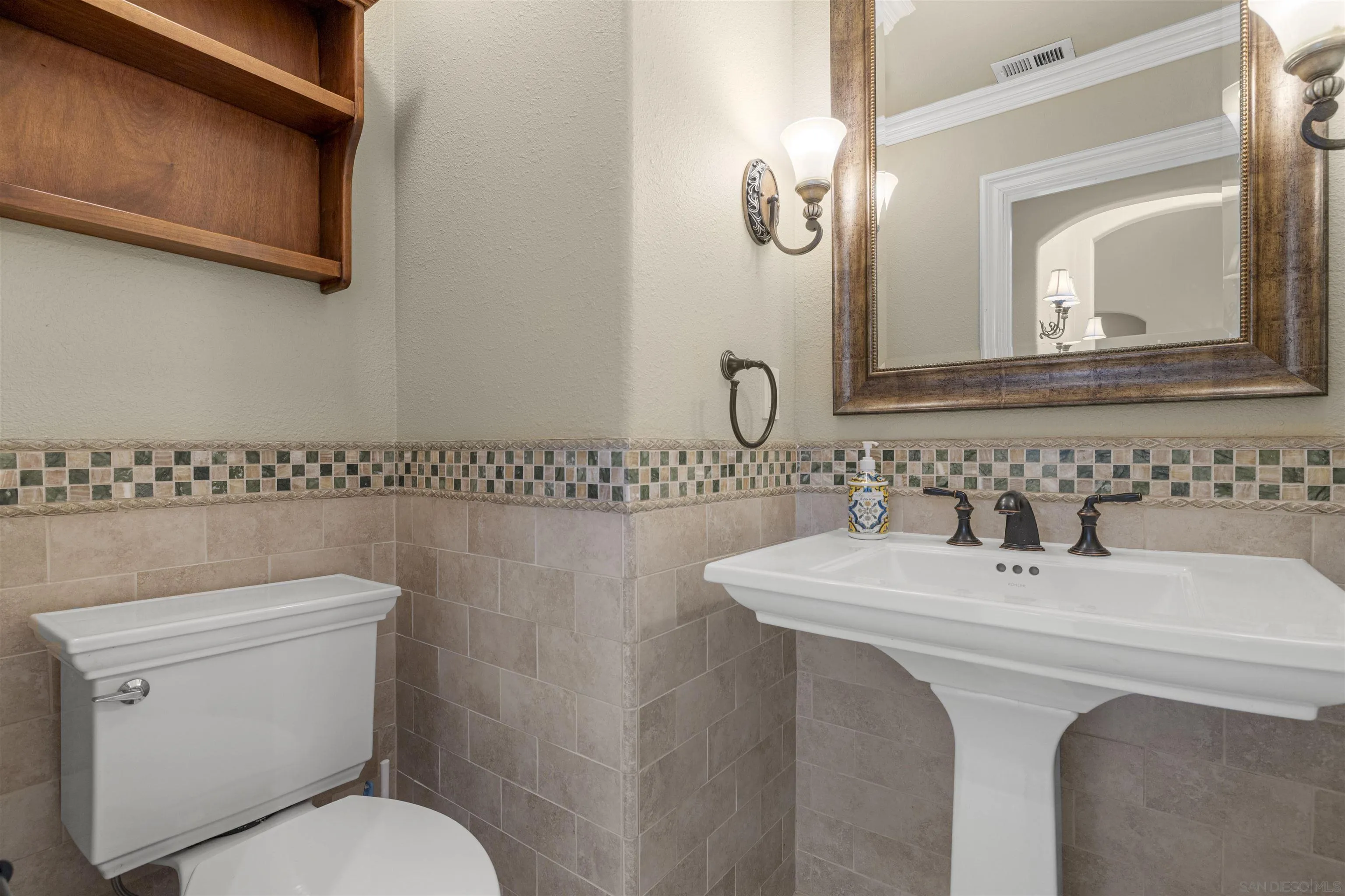 1315 Macadamia Drive Fallbrook, CA 92028 - Photo 20 of 59 a bathroom with a toilet a sink and mirror