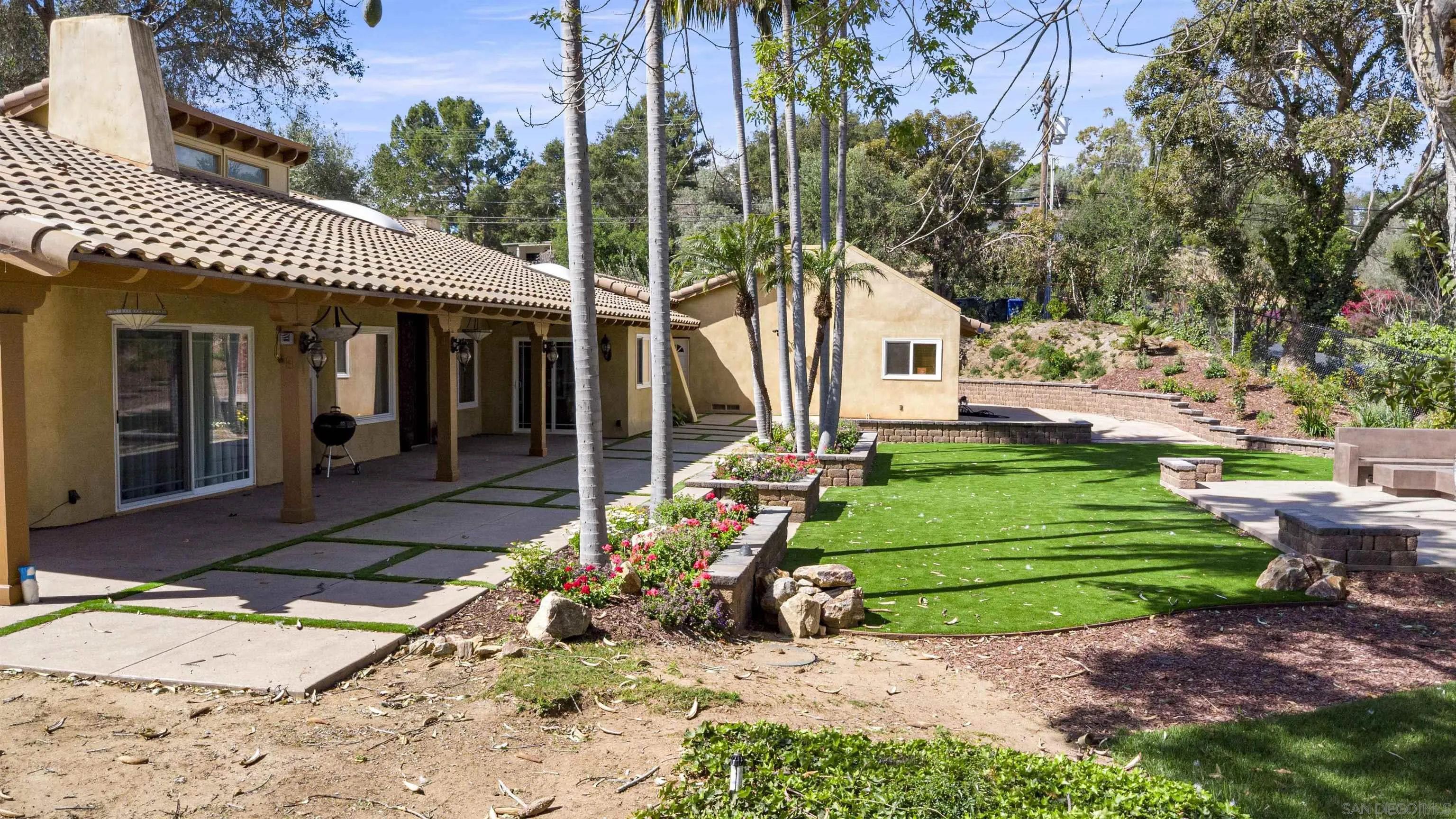 1315 Macadamia Drive Fallbrook, CA 92028 - Photo 9 of 59 a front view of a house with a garden and trees