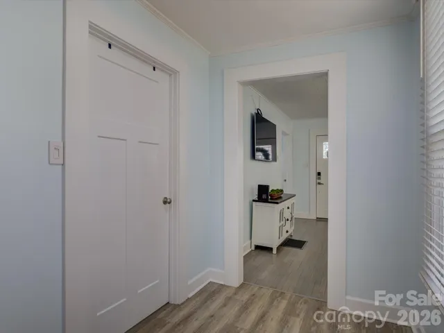 a view of a hallway with closet and wooden floor
