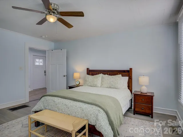 a bedroom with a bed chandelier and a window