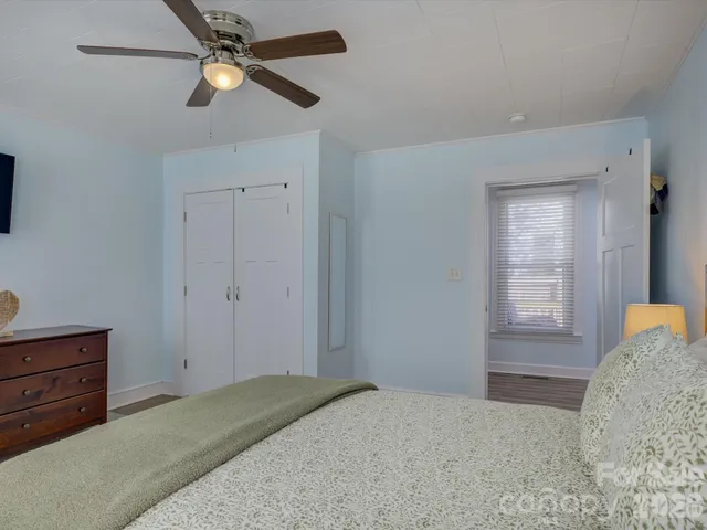 a bedroom with a bed and a ceiling fan