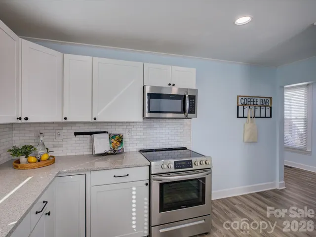 a kitchen with stainless steel appliances granite countertop a stove a microwave and cabinets