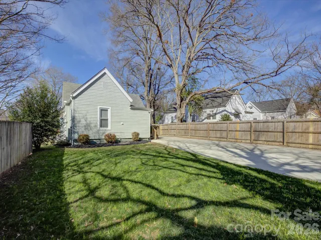 a view of backyard of house with green space