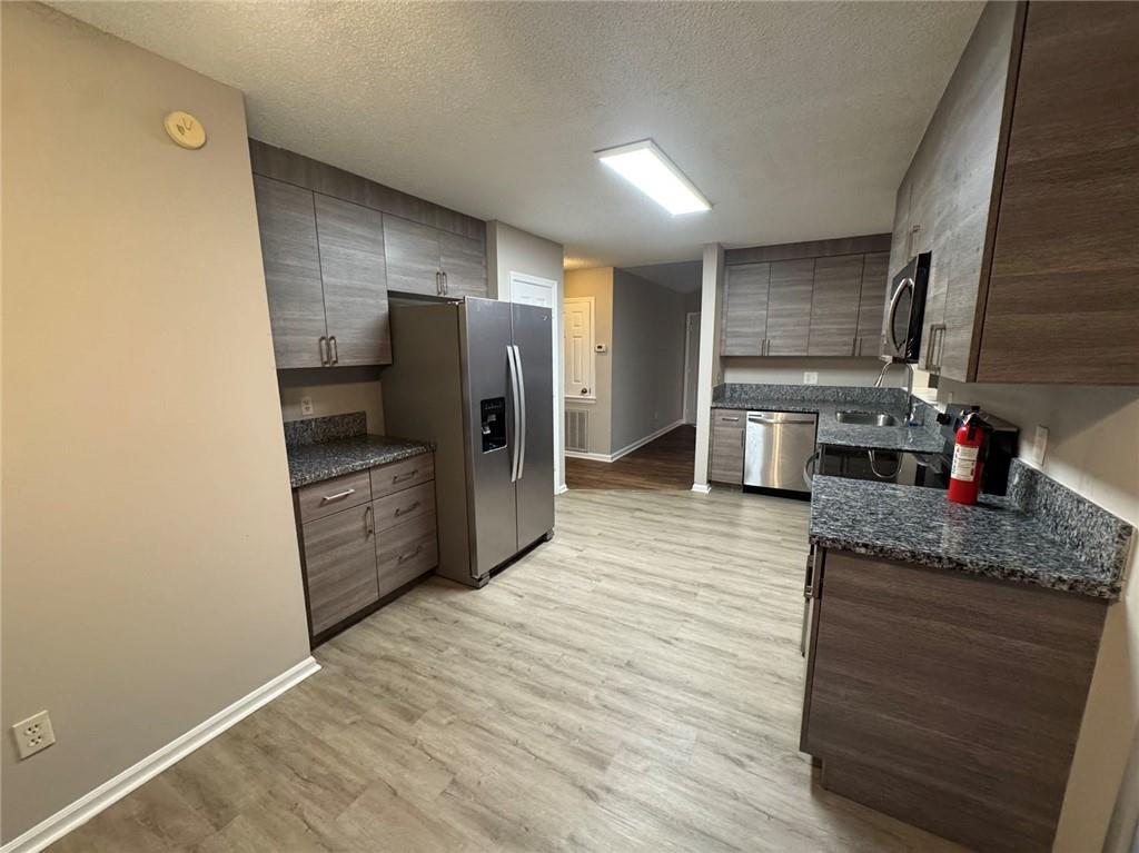 316 Ridgestone Drive Warner Robins, GA 31088 - Photo 4 of 21 a kitchen with stainless steel appliances kitchen island granite countertop a refrigerator and a sink