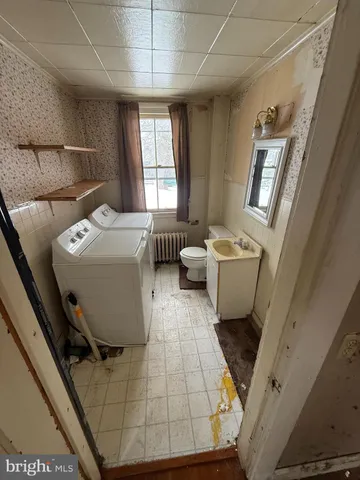 a living room with stainless steel appliances kitchen island granite countertop furniture a rug and white cabinets