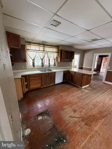a living room with stainless steel appliances furniture a fireplace and wooden floor