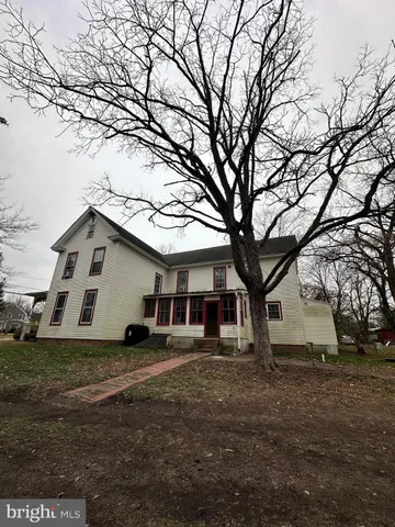 a white house that has a tree in front of it