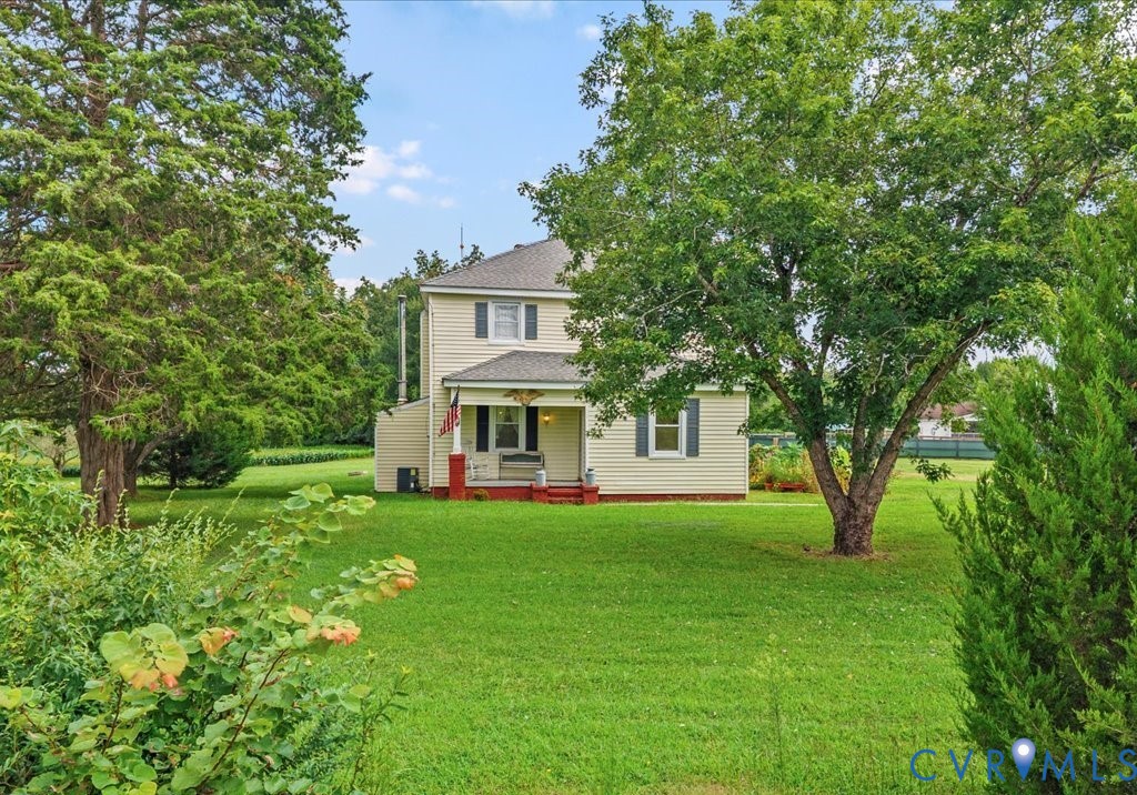 Rear view of house featuring a shingled roof, a ya