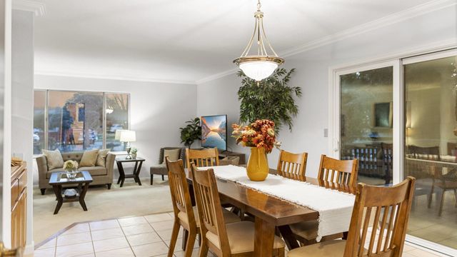 a view of a dining room and livingroom with furniture wooden floor a chandelier