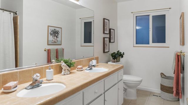 a bathroom with a granite countertop sink toilet and mirror