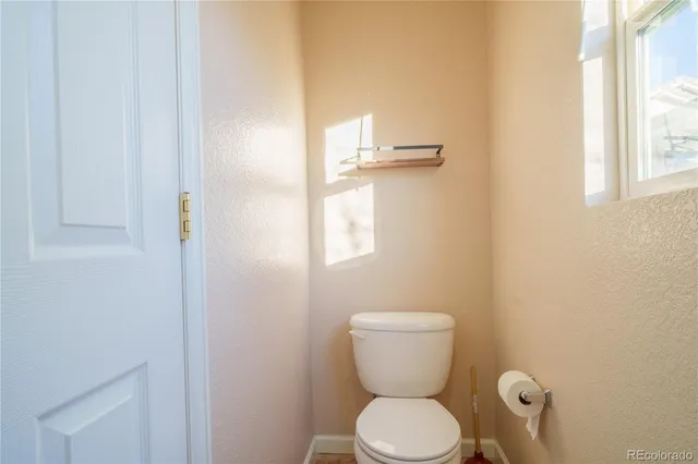a bathroom with a toilet and a window