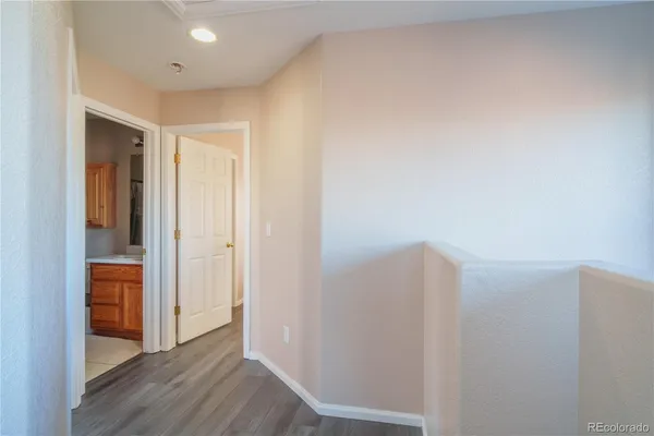 a view of hallway with closet and wooden floor