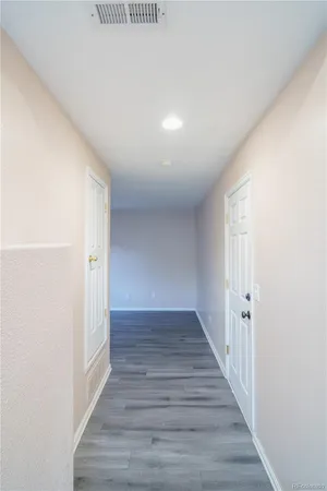 a view of a hallway with wooden floor