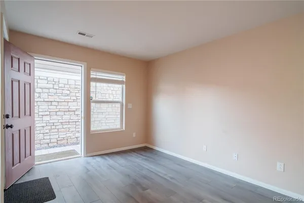 an empty room with wooden floor and window