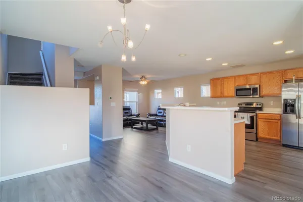a view of kitchen with refrigerator microwave and stove with wooden floor