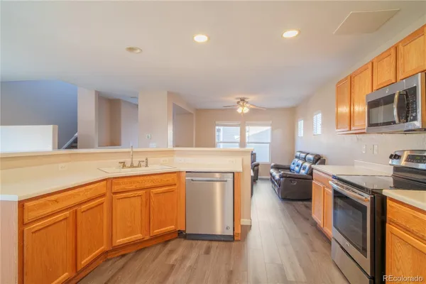 a kitchen with stainless steel appliances granite countertop a sink stove and wooden cabinets
