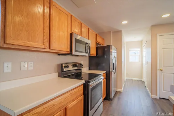 a kitchen with stainless steel appliances granite countertop a refrigerator a stove and a wooden floors
