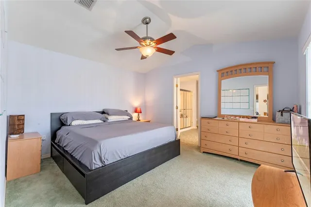 a bedroom with a bed and a chandelier fan
