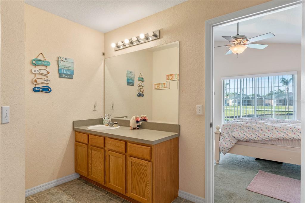 233 Reserve Drive Davenport, FL 33896 - Photo 20 of 25 a en suite bathroom with a granite countertop sink a mirror and shower