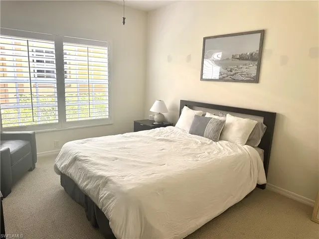 a large bed sitting in a bedroom next to a window