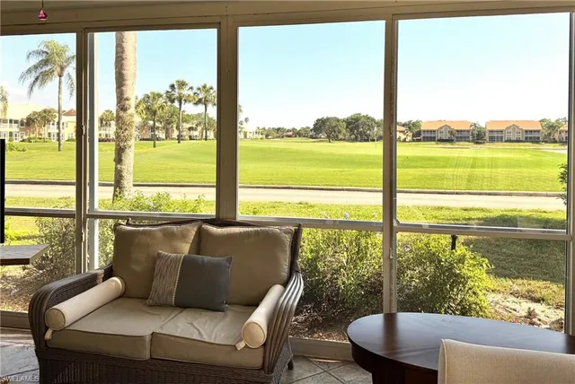 a living room with furniture and a floor to ceiling window