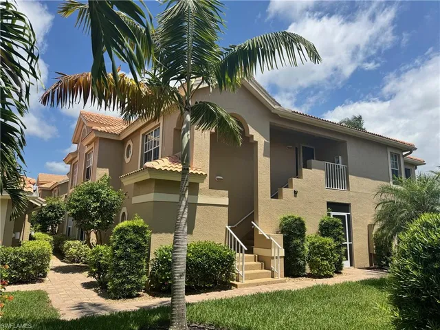front view of a house with a palm tree
