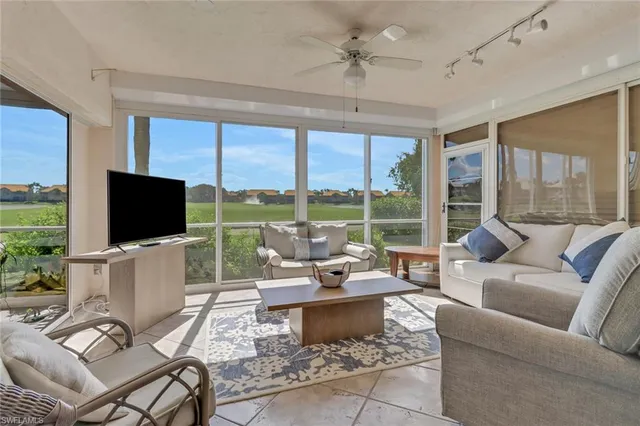 a living room with patio furniture and a flat screen tv