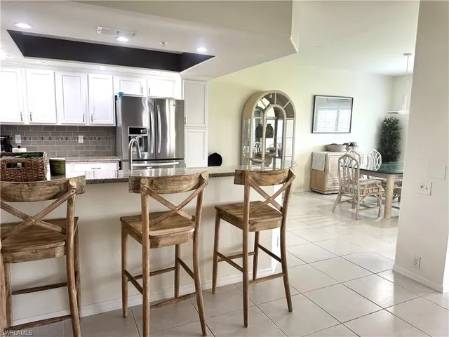 a dining hall with stainless steel appliances a stove a dining table and chairs with wooden floor