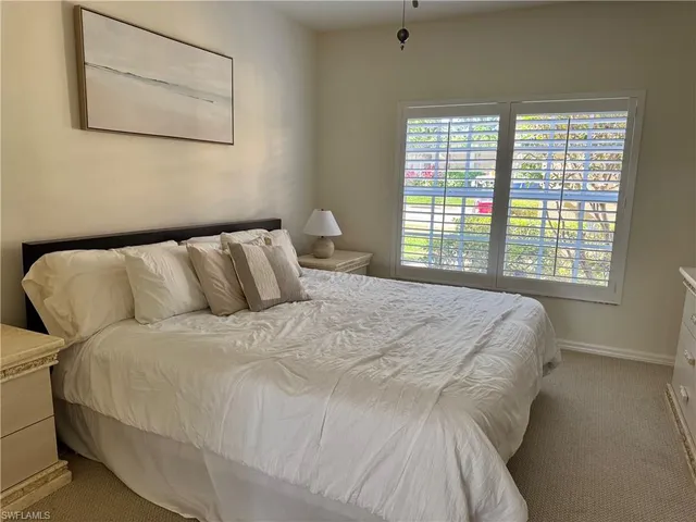 a large bed sitting in a bedroom next to a window