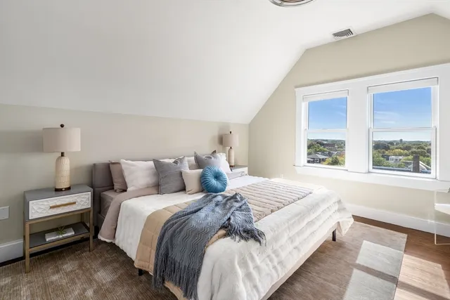 a large bed sitting in a bedroom next to a window