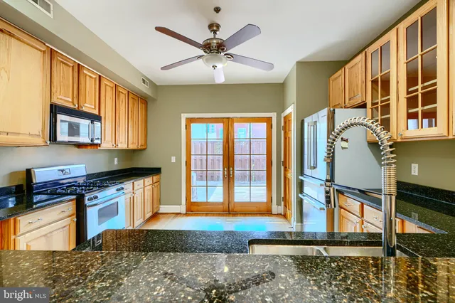 a kitchen with stainless steel appliances granite countertop a stove a sink and a microwave