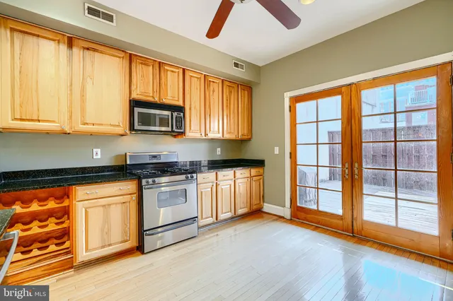 a kitchen with stainless steel appliances granite countertop a stove a sink and a microwave