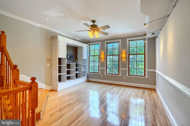a view of an empty room with window and wooden floor