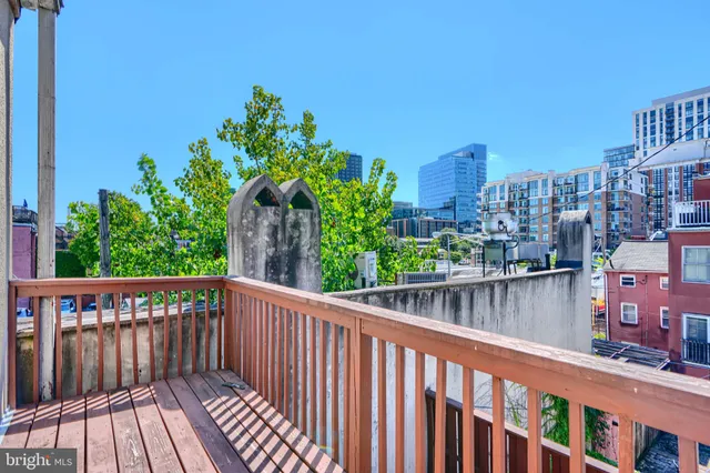 a balcony with wooden floor and city view