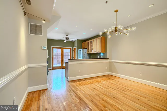 a view of a room with wooden floor and a ceiling fan
