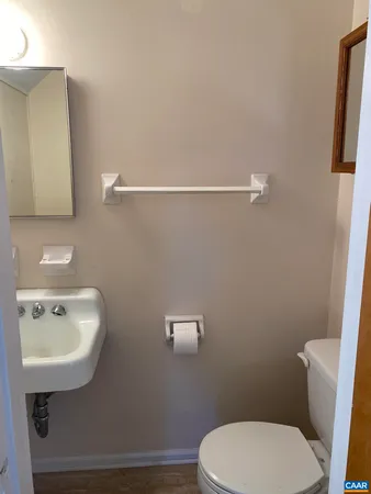 a bathroom with a toilet a sink and mirror