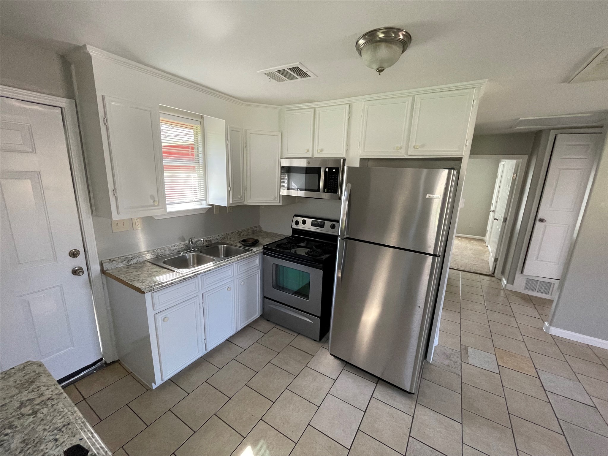 1041 Lott Avenue Austin, TX 78721 - Photo 6 of 14 a kitchen with granite countertop a refrigerator and a stove top oven