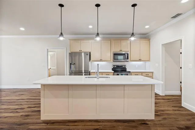 a kitchen with stainless steel appliances granite countertop a sink a stove and a wooden floor