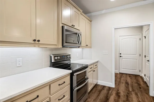 a kitchen with a sink a center island a wooden floor and a chandelier