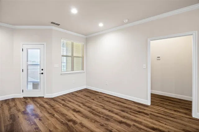 a kitchen with cabinets stainless steel appliances and wooden floor