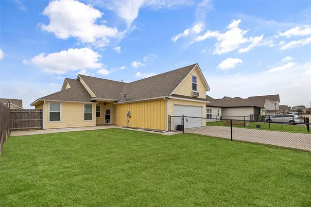a view of a house with a big yard plants and large trees