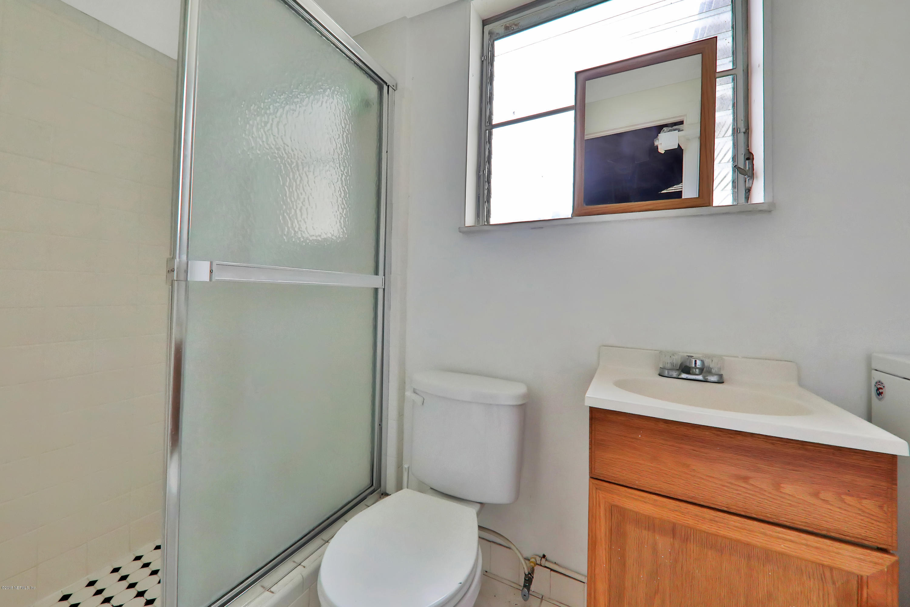 2519 Sam Road Jacksonville, FL 32216 - Photo 21 of 26 a bathroom with a toilet sink vanity and mirror
