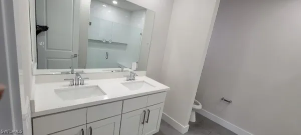 a bathroom with a sink toilet and a mirror