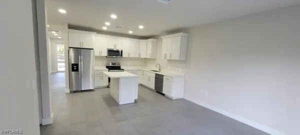 a kitchen with white cabinets and white appliances