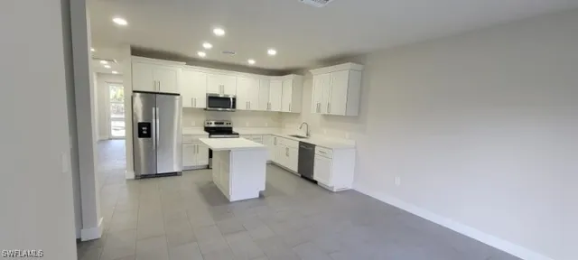 a kitchen with white cabinets and white appliances