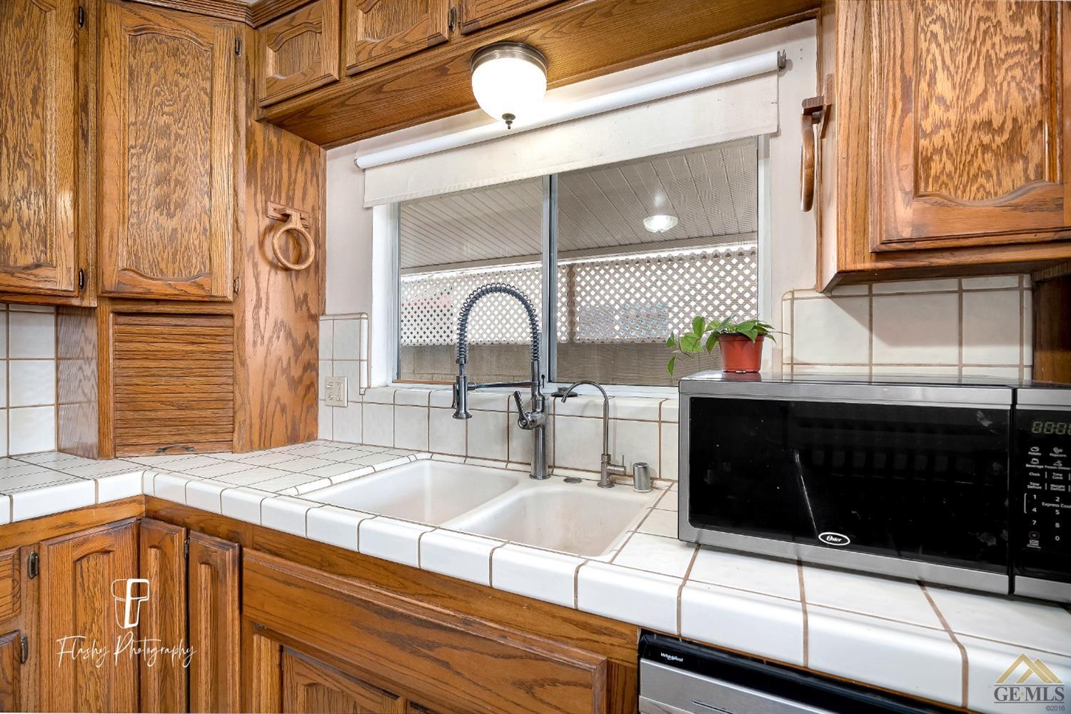 Undisclosed Address Bakersfield, CA 93304 - Photo 16 of 38 a kitchen with stainless steel appliances kitchen island granite countertop a sink and cabinets