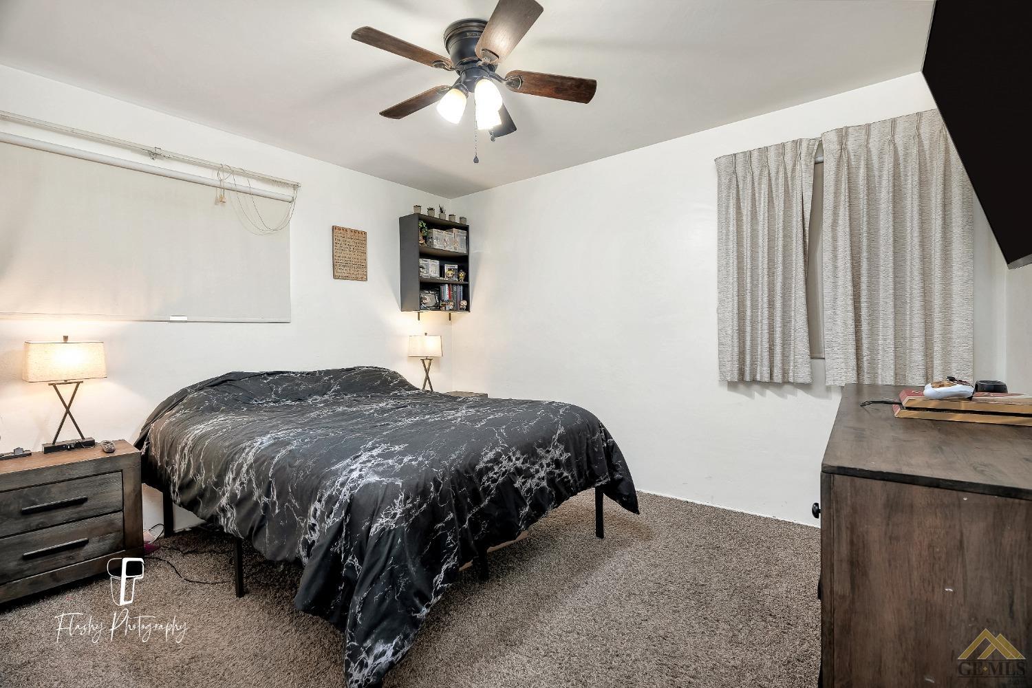 Undisclosed Address Bakersfield, CA 93304 - Photo 26 of 38 a bedroom with a bed and a chandelier