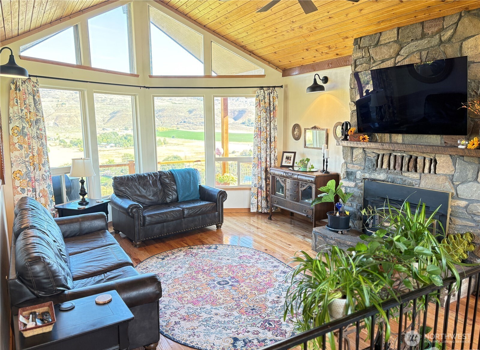8 Mundinger Lane Omak, WA 98841 - Photo 3 of 37 a living room with furniture a flat screen tv and a floor to ceiling window