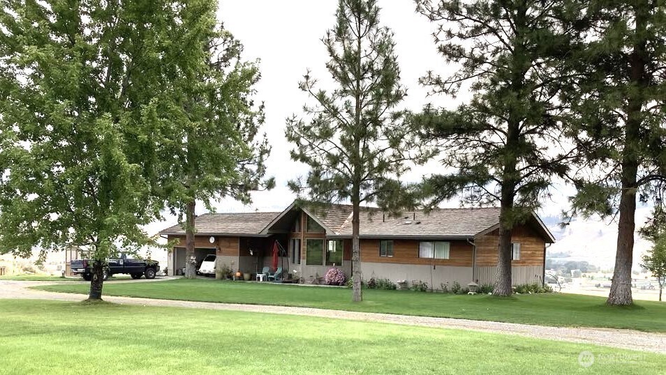 8 Mundinger Lane Omak, WA 98841 - Photo 32 of 37 a tree in front of a building with a garden